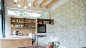 A kitchen with wooden cabinets, a countertop, and a dining area with a table and chairs.