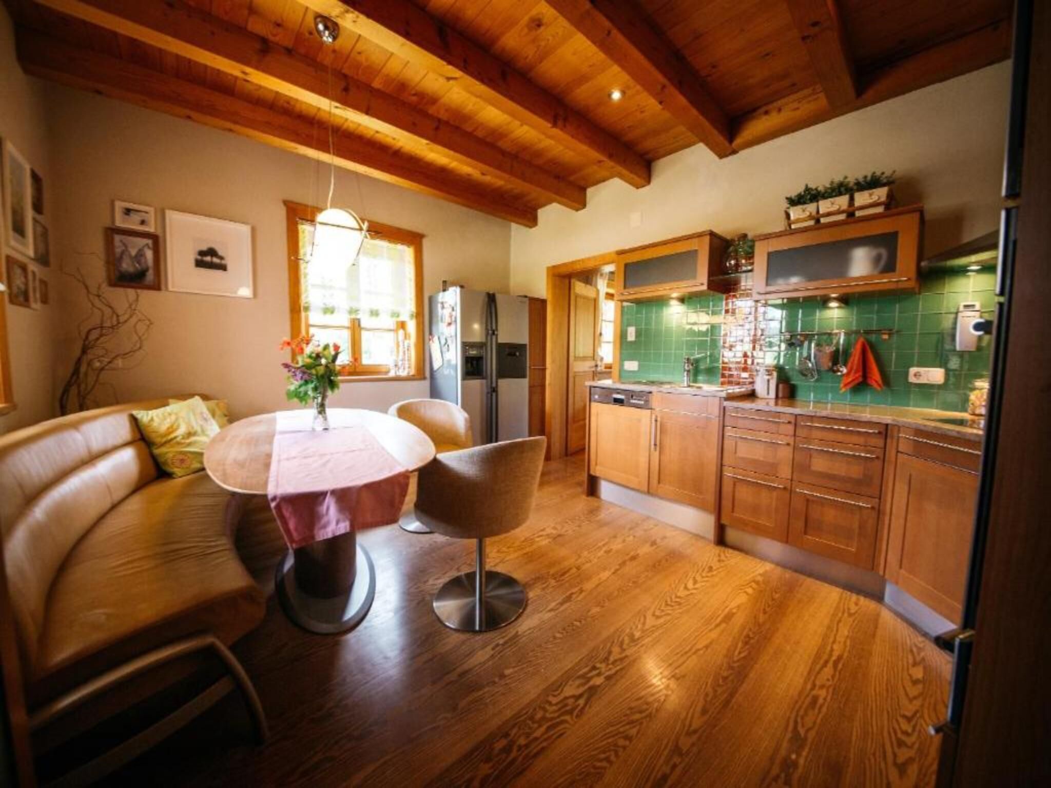A cozy kitchen with wooden cabinets, a dining area with a round table and chairs, and a built-in oven.