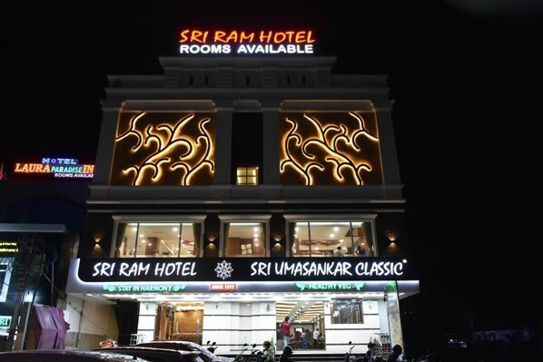 Ein Hotel mit einem Schild, das 'Zimmer frei' und 'Sri Ram Hotel' anzeigt.