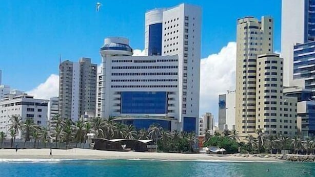 A coastal cityscape with modern high-rise buildings, a beach, and clear blue water. - Hotel Almirante Cartagena Colombia (Cartagena)