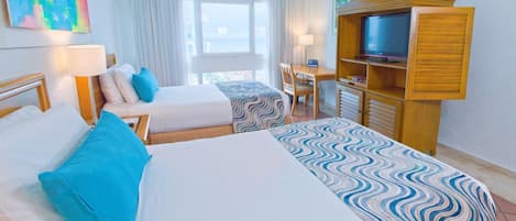 A hotel room with two beds, a TV, a desk, and a chair.