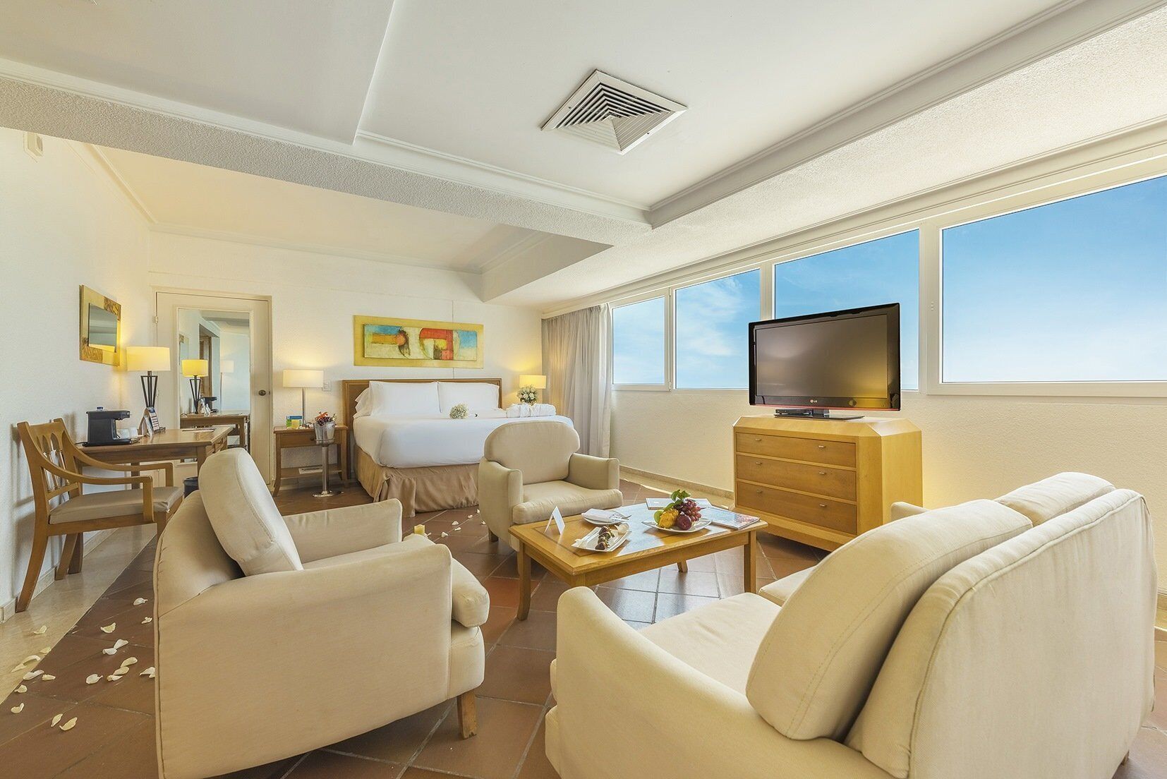 Une chambre d’hôtel équipée d’un lit, d’une télévision, d’un bureau, d’une chaise et d’un canapé.