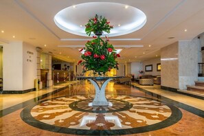 A lobby with a central fountain, a reception desk, and a seating area. - Hotel Almirante Cartagena Colombia (Cartagena)