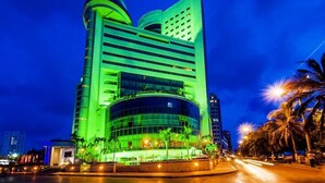 A modern hotel with a curved facade, multiple floors, and a prominent entrance with a glass canopy. - Hotel Almirante Cartagena Colombia (Cartagena)