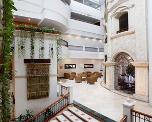 Un atrium à plusieurs niveaux, doté d’un escalier central, d’espaces de repos et d’une colonne décorative.