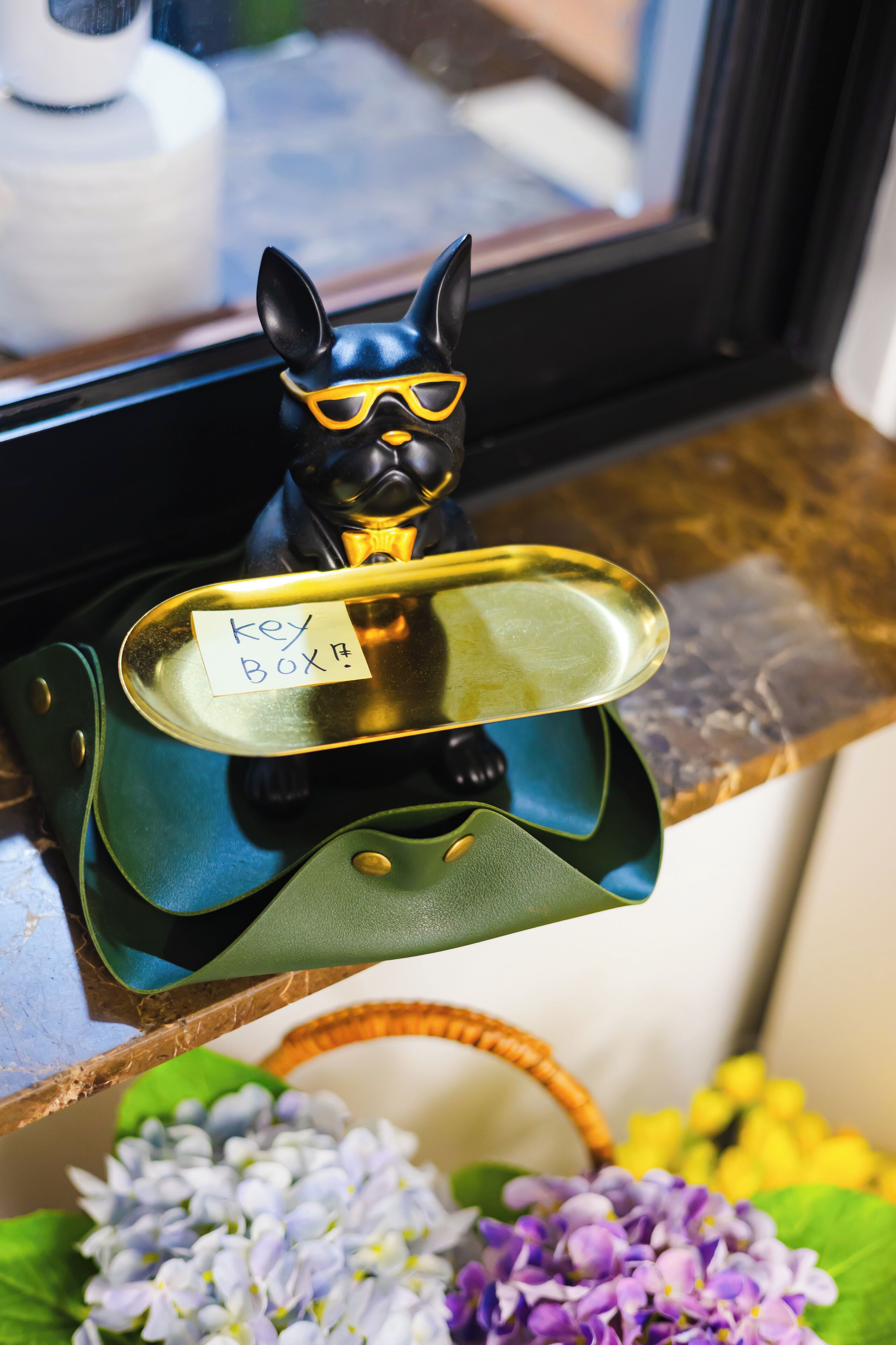 A key box on a counter with a decorative item above it.