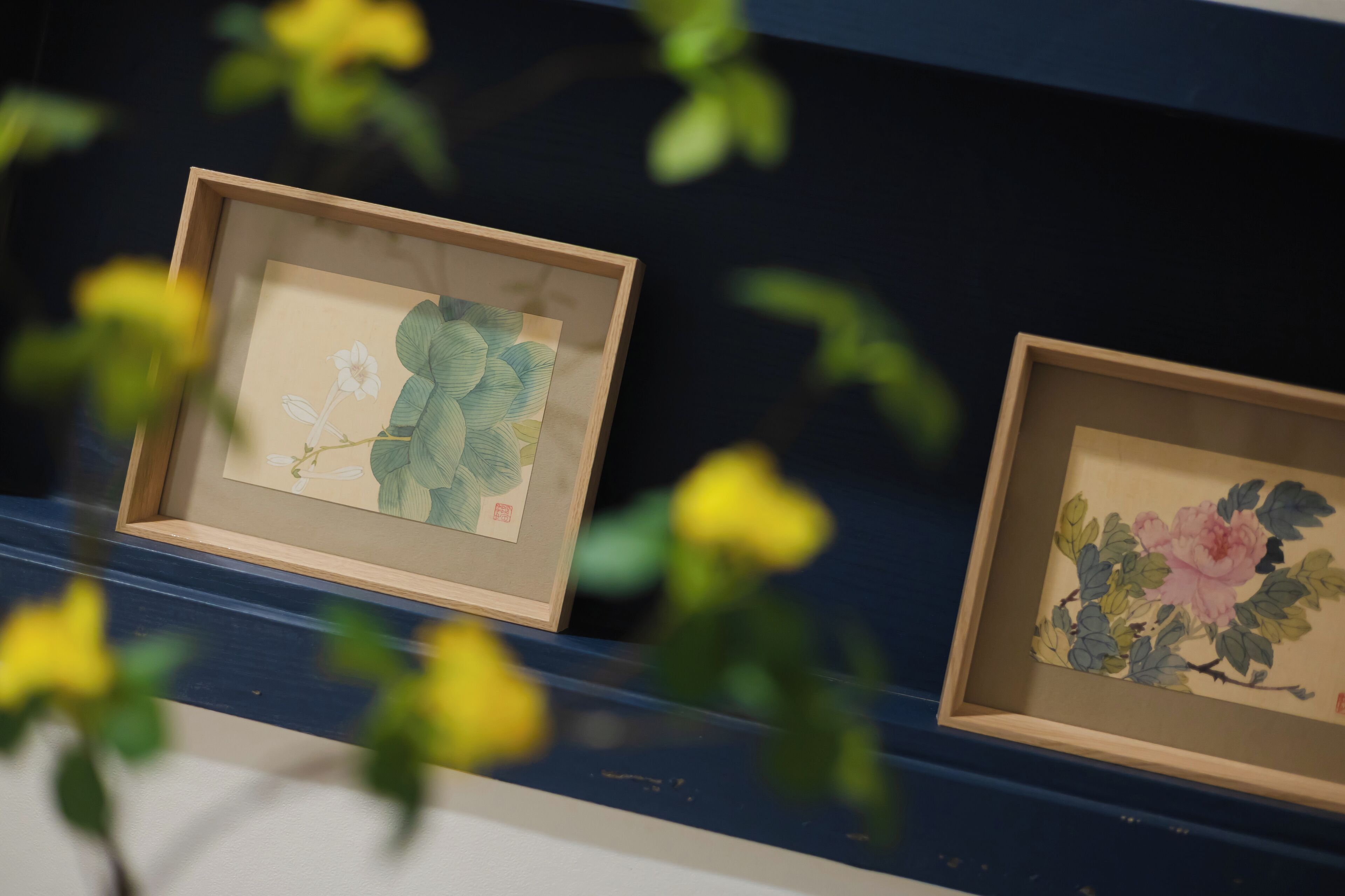 Two framed artworks on a wall.