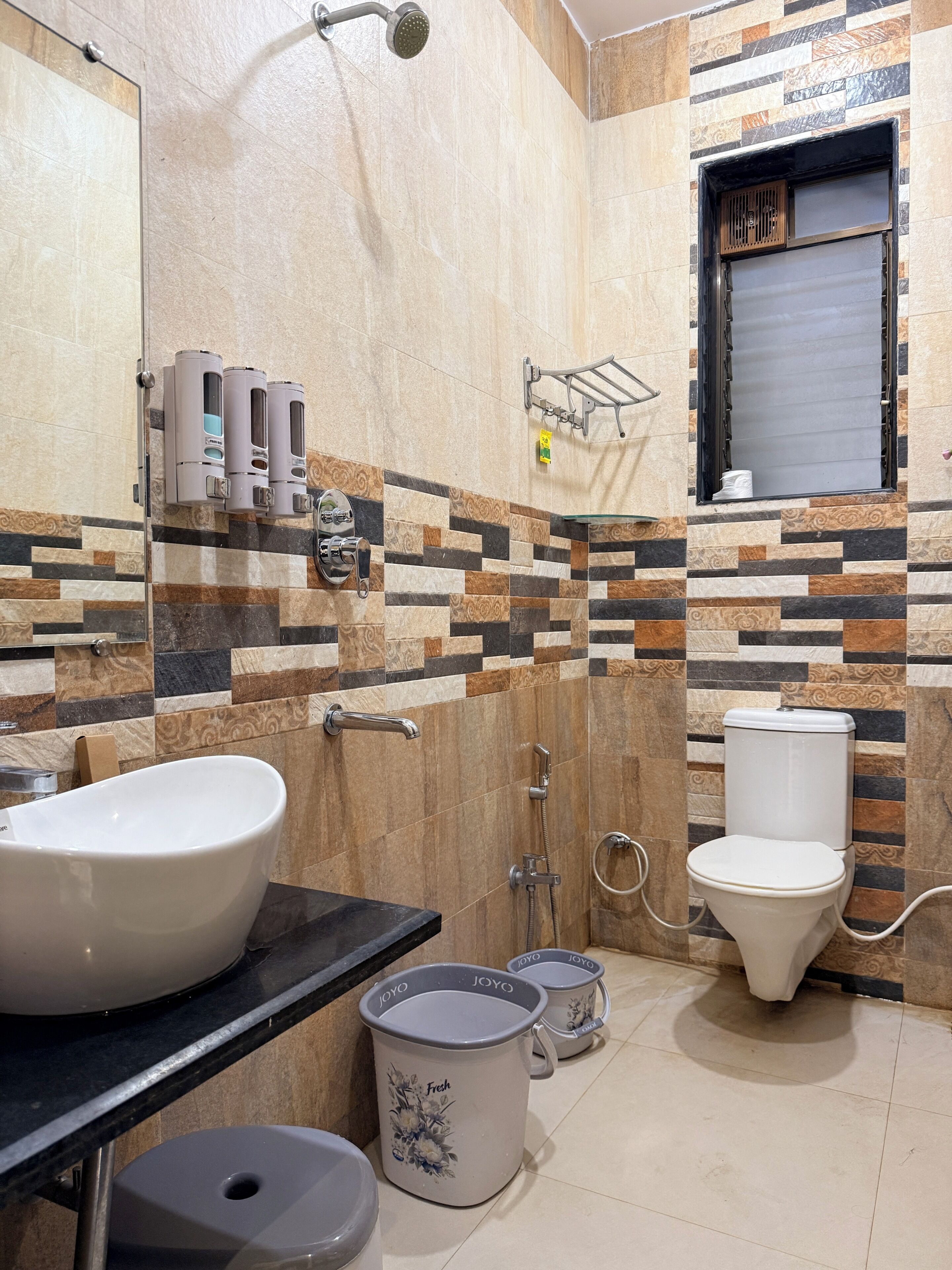 A bathroom with a large sink, toilet, and shower.