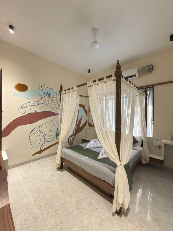 A four-poster canopy bed with a wooden frame and white drapes, a ceiling fan, and an air conditioning unit on the wall. - LaFiesta Resort By Greenleaf Aqua (Alibag)