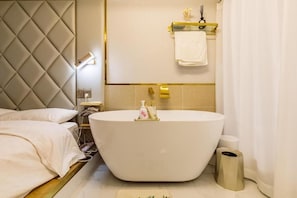 A modern bathroom with a freestanding bathtub, a vanity with a mirror, and a towel rack. - Shanghai Stylish Loft with 2B (Shanghai)