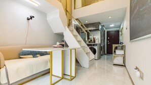 A modern interior with a staircase, a sofa, a small table, and a kitchen area. - Shanghai Stylish Loft with 2B (Shanghai)