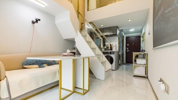 A modern interior with a staircase, a sofa, a small table, and a kitchen area. - Shanghai Stylish Loft with 2B (Shanghai)