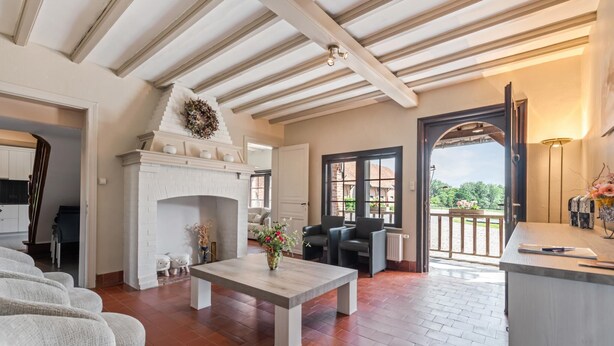 A spacious living room with a fireplace, a dining area, and a view of the outdoors.