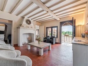 A spacious living room with a fireplace, a dining area, and a view of the outdoors.