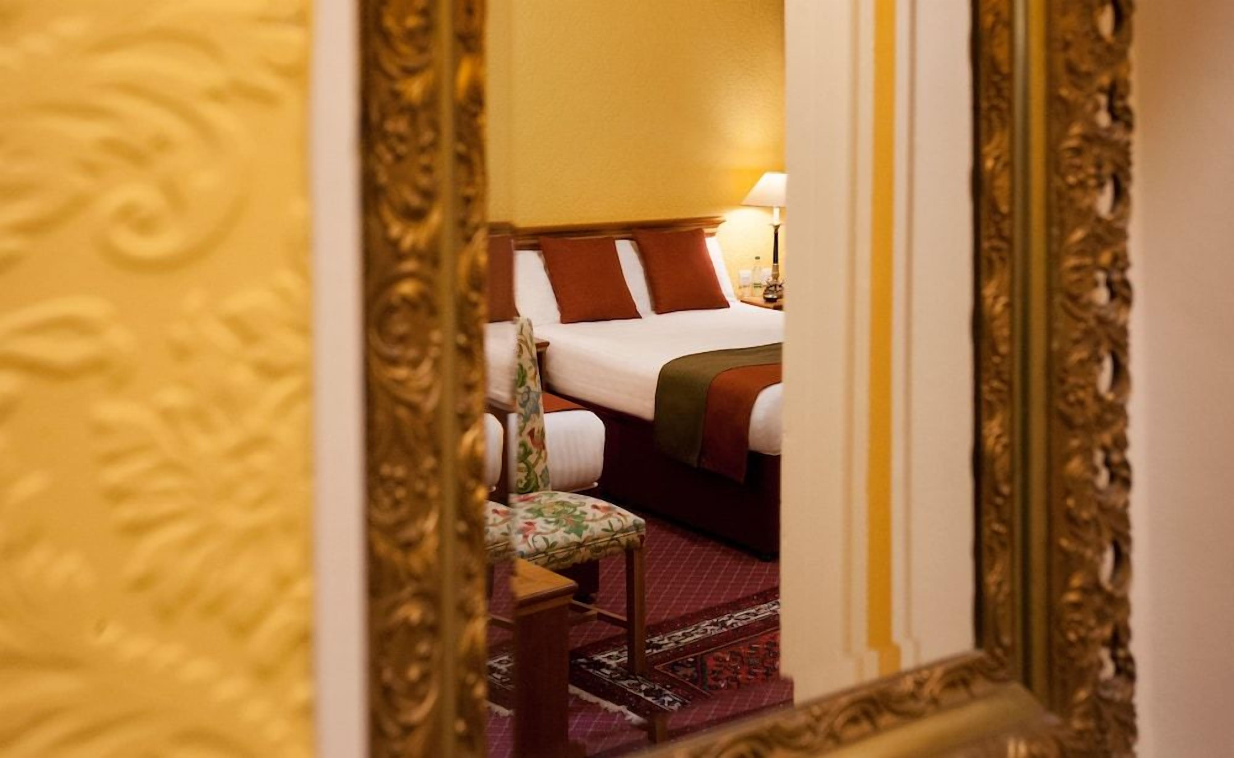 Een hotelkamer met een bed, een stoel en een lamp.