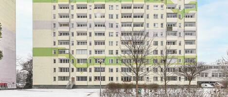 Un edificio de varios pisos con fachada uniforme, balcones y techo plano.