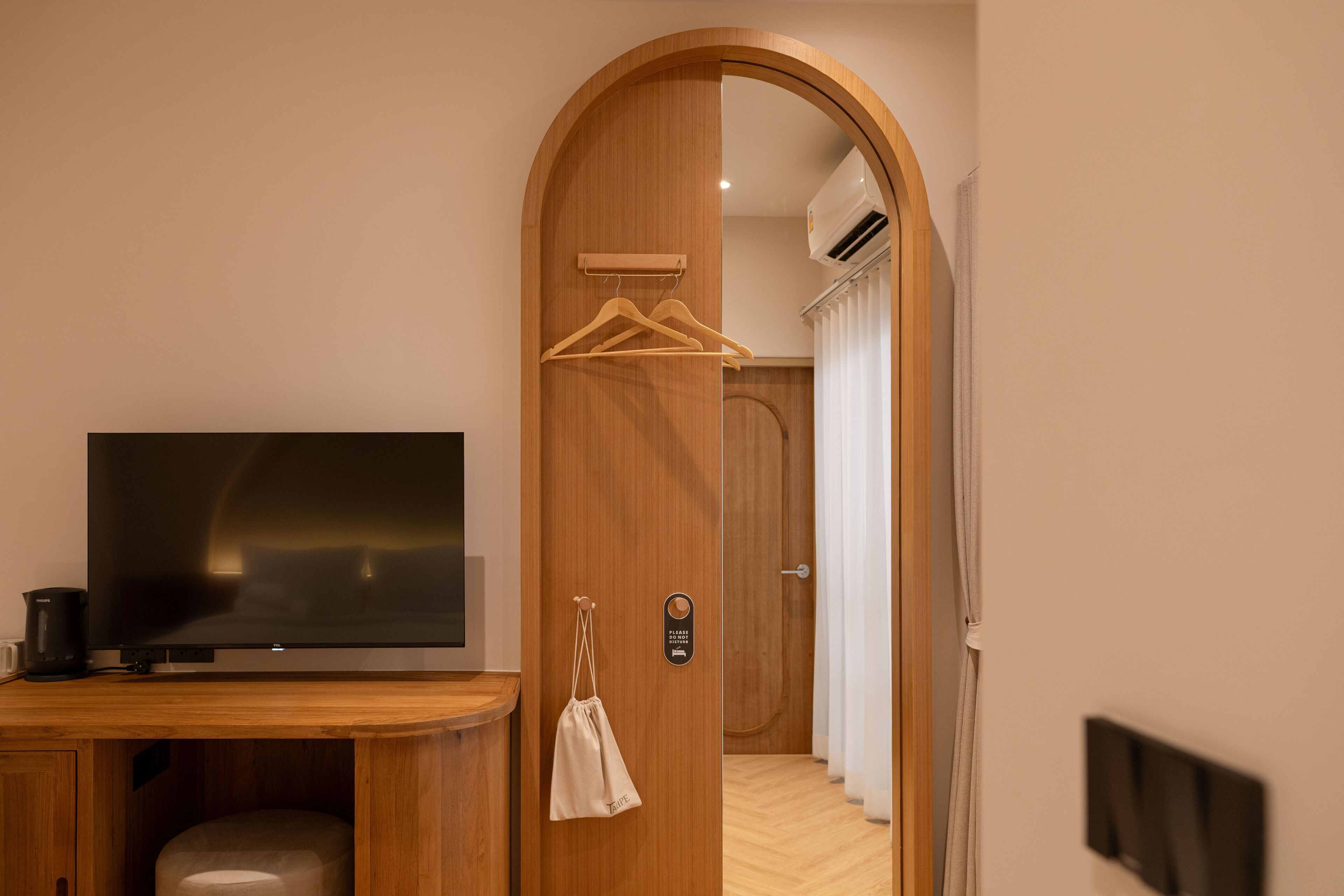Une porte en bois avec un téléviseur, un sac suspendu et une pancarte.