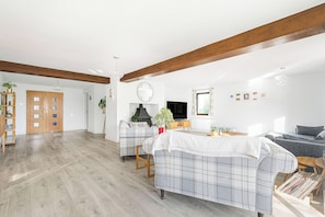 Un salon spacieux avec une cheminée, deux canapés et un plancher en bois.
