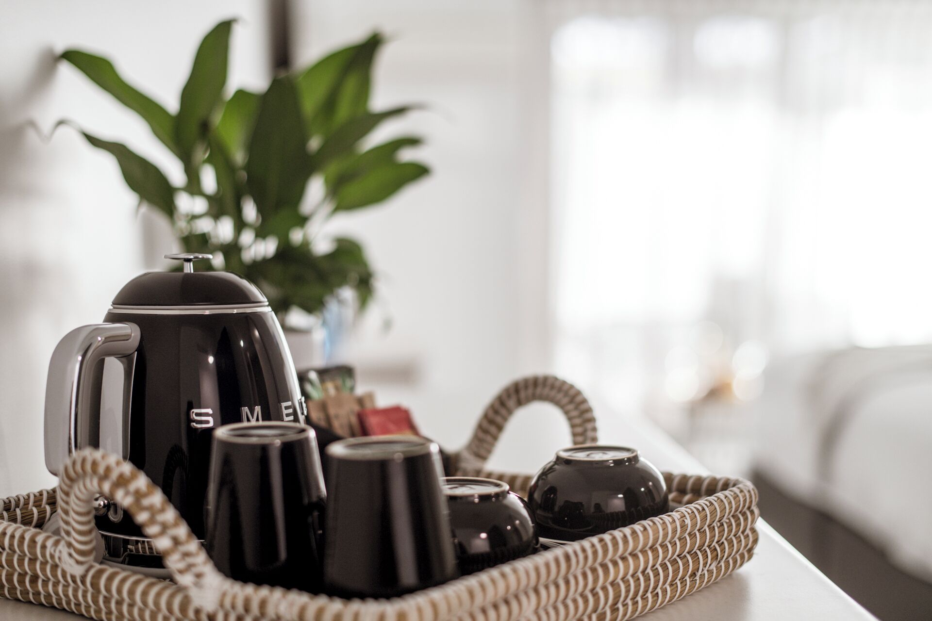 A tray with a coffee maker, cups, and a thermos on a table.