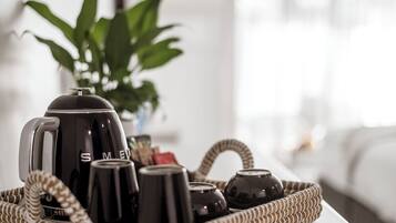 A tray with a coffee maker, cups, and a thermos on a table.