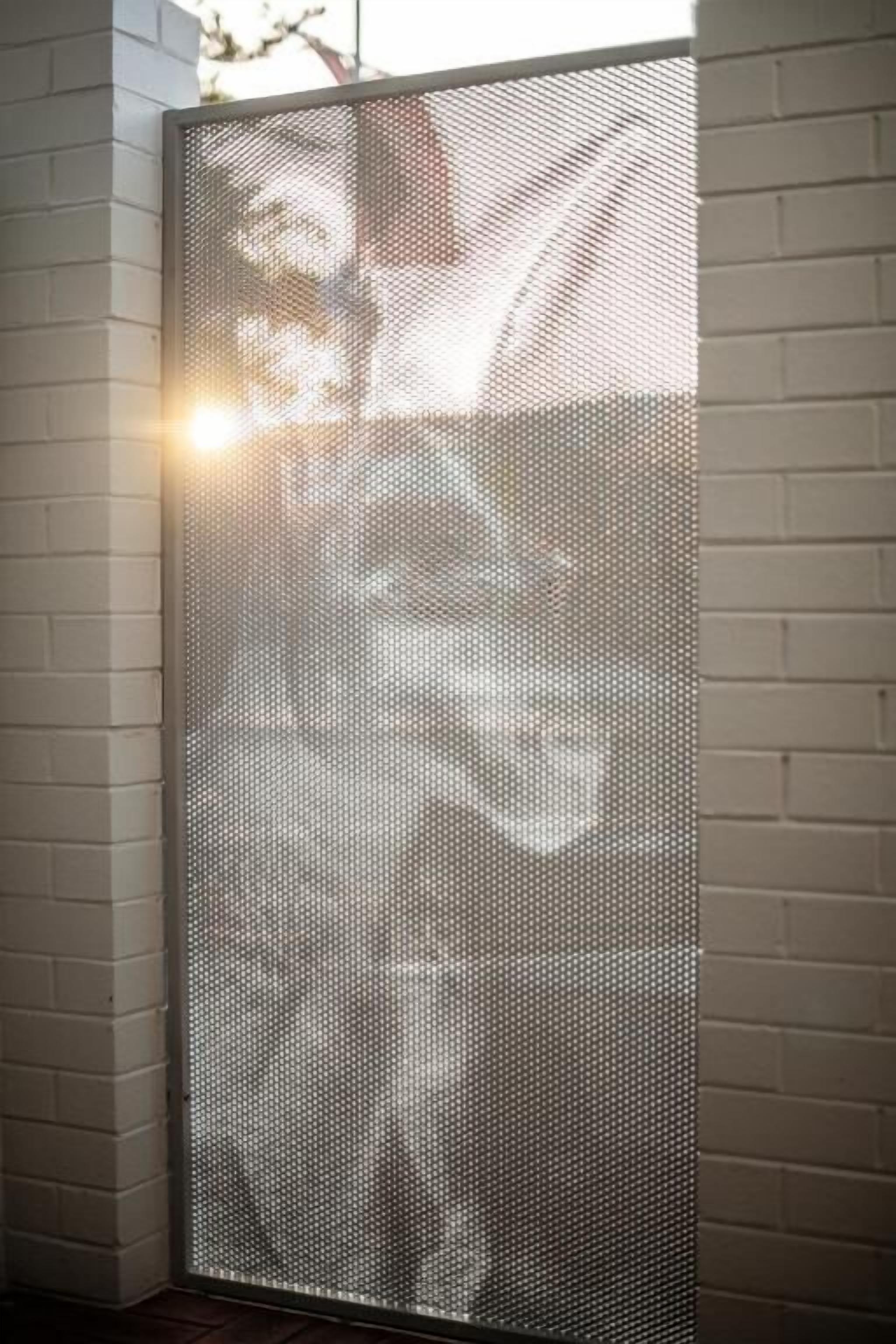 A room with a white brick wall and a large, textured partition.