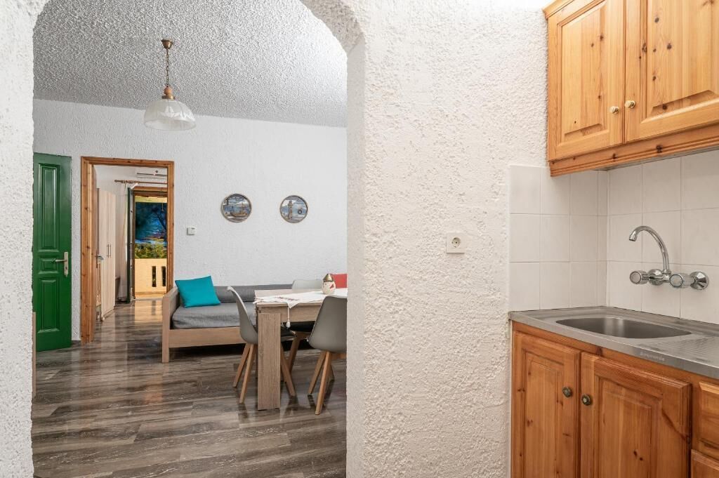 A compact kitchen with wooden cabinets and a stainless steel sink.