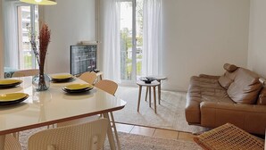 Una sala de estar moderna con comedor, un sofá de cuero marrón y una mesa de comedor con platos amarillos.