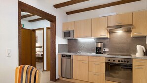 A modern kitchen with wooden cabinets, a built-in microwave, a dishwasher, and a stainless steel oven. - Apartment 3 with Balcony, Barbecue Area and Wi-Fi (Oberharmersbach)