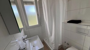 Ein Badezimmer mit Waschbecken, Toilette und Duschvorhang.