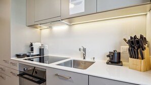 Eine moderne Küche mit zwei Edelstahl-Spülen, einer Kaffeemaschine und einem Messerblock.