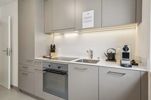 Una cuina moderna amb electrodomèstics d'acer inoxidable, una doble rentavaixelles i un forn encastrat.