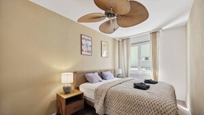 A hotel room with a bed, a nightstand, a ceiling fan, and a window with curtains. - Luxury Apartment close to the city center! (Zürich)