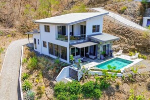 A modern two-story house with a pool, surrounded by natural landscape. - Modern & Scenic Haven | Breathtaking Views - Pool (Coco)