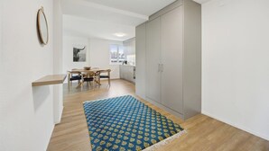 A modern apartment with a dining area, kitchen, and a large wardrobe. - Moderne Wohnung in Zürich Oerlikon! (201) (Zürich)