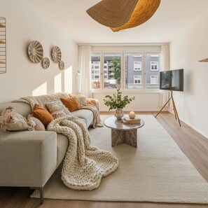 A cozy living room with a sofa, a coffee table, and a TV. - Cozy apartment in Oerlikon (102) (Zürich)