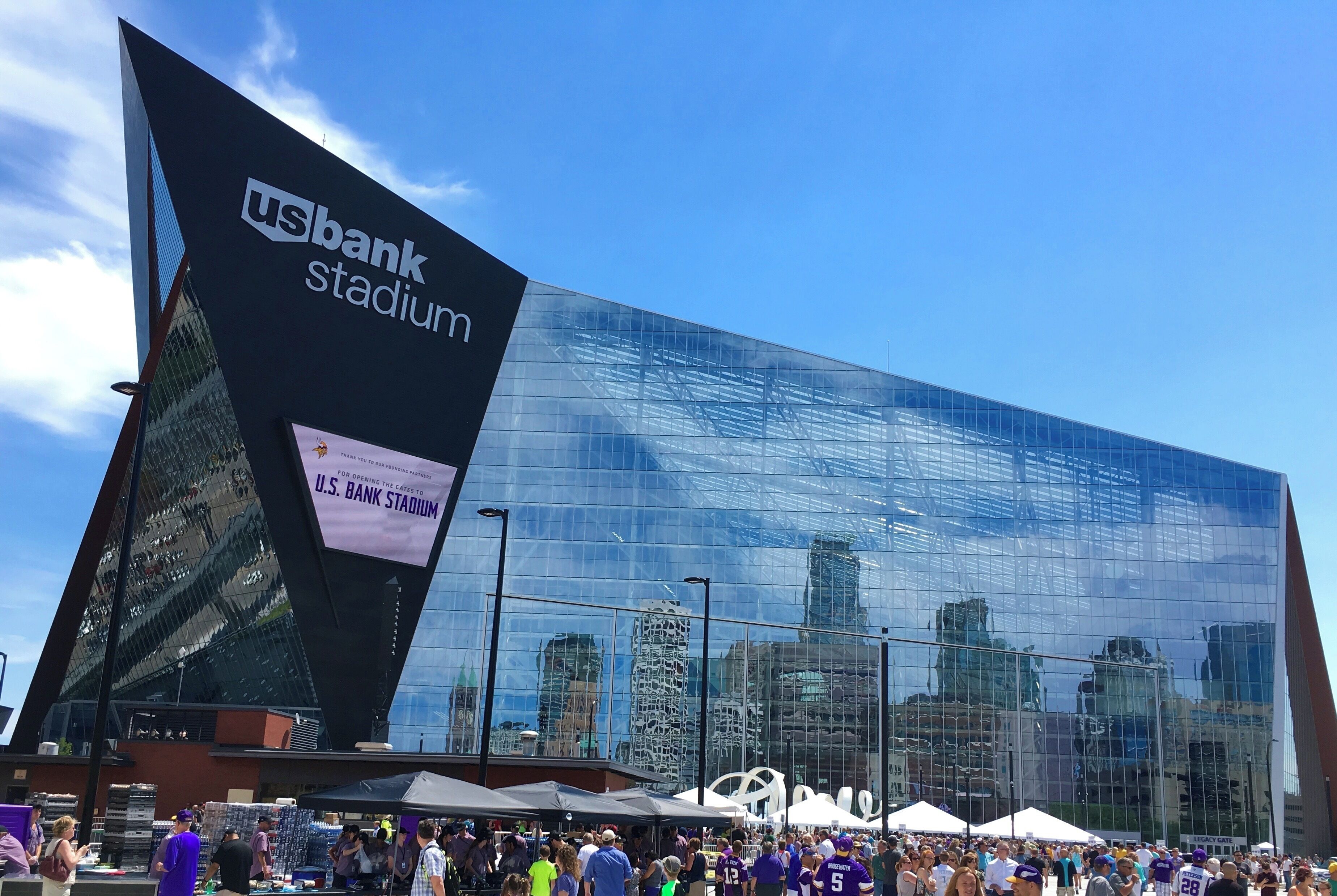Un stade moderne doté d’une façade en verre et d’une grande enseigne indiquant le nom du « US Bank Stadium ».