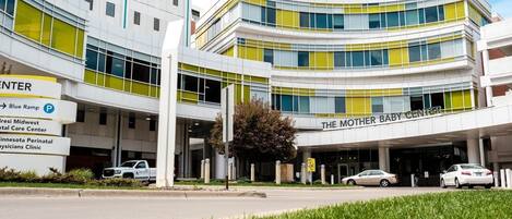 A modern building with multiple entrances, including a prominent sign for 'The Mother Baby Center.'