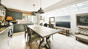 Eine moderne Küche mit Essbereich, großen Fenstern und Blick ins Freie.