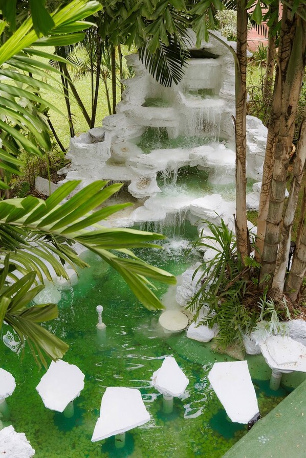 A tranquil garden with a cascading water feature surrounded by lush greenery.