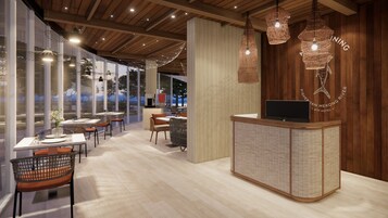 Un restaurante con techo y paredes de madera, muebles de mimbre e iluminación colgante.