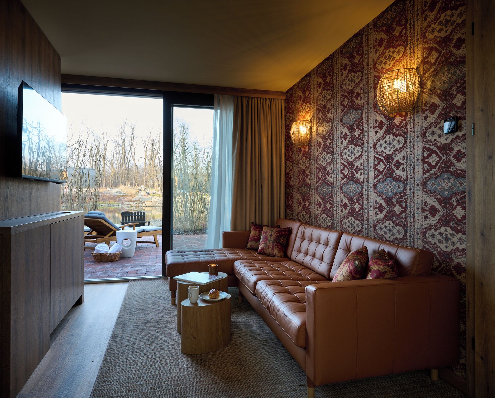 A modern living room with a leather sofa, a coffee table, and a TV mounted on the wall.