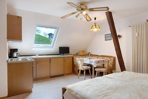 A bedroom with a bed, a desk with a chair, a window, and a ceiling fan. - Studio 7 with Mountain View, Barbecue Area and Wi-Fi (Oberharmersbach)
