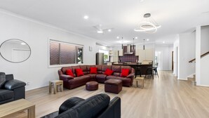 A modern living room with a sectional sofa, a coffee table, and a black leather couch. - Suitable for Large Groups / Near Beach / Family Fr (The Entrance North)
