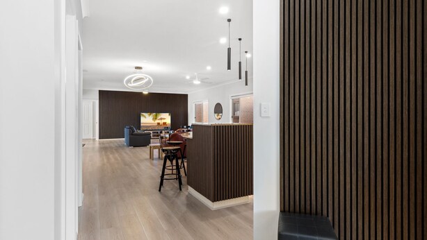 A modern living room with a TV, seating, and a wooden accent wall. - Suitable for Large Groups / Near Beach / Family Fr (The Entrance North)