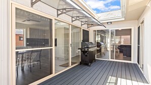 A covered outdoor deck with a grill and seating area. - Suitable for Large Groups / Near Beach / Family Fr (The Entrance North)