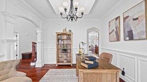 Een ruime kamer met een houten bureau, boeken, een wereldbol en een boekenkast.