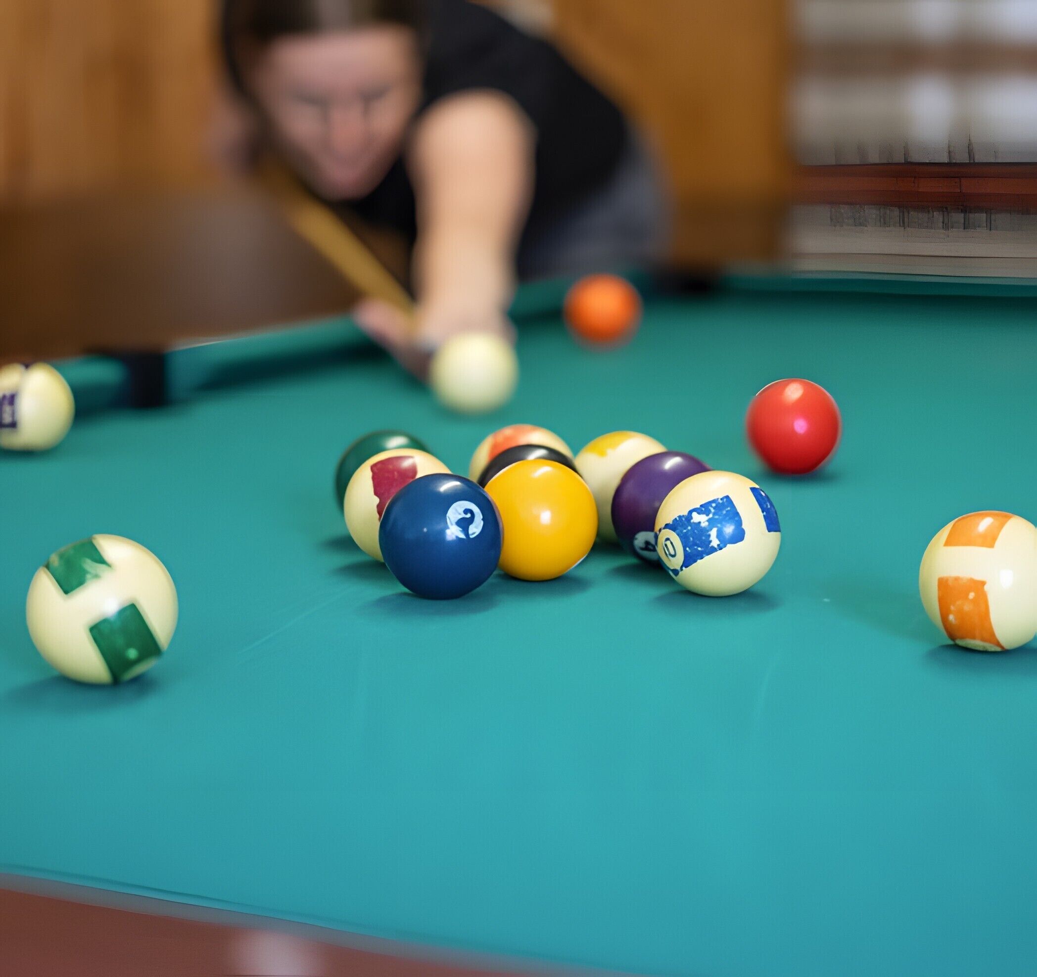Un tavolo da biliardo con palle di diversi colori e un bastone da gioco.