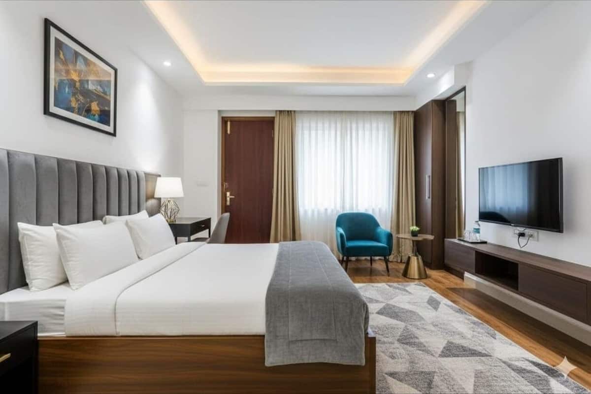 Una habitación de hotel moderna con una cama grande, un televisor, un escritorio y una silla.