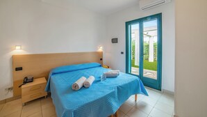 Una camera da letto con un letto, un comodino e un condizionatore d'aria.