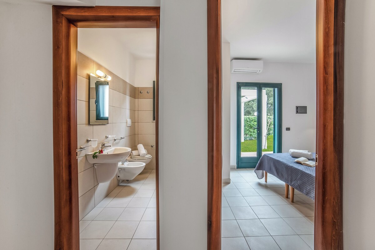 A bathroom with a sink, toilet, and mirror.